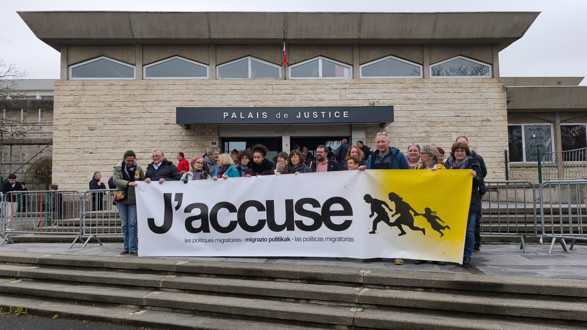 Personas concentradas delante del Palacio de Justicia portando una pancarta